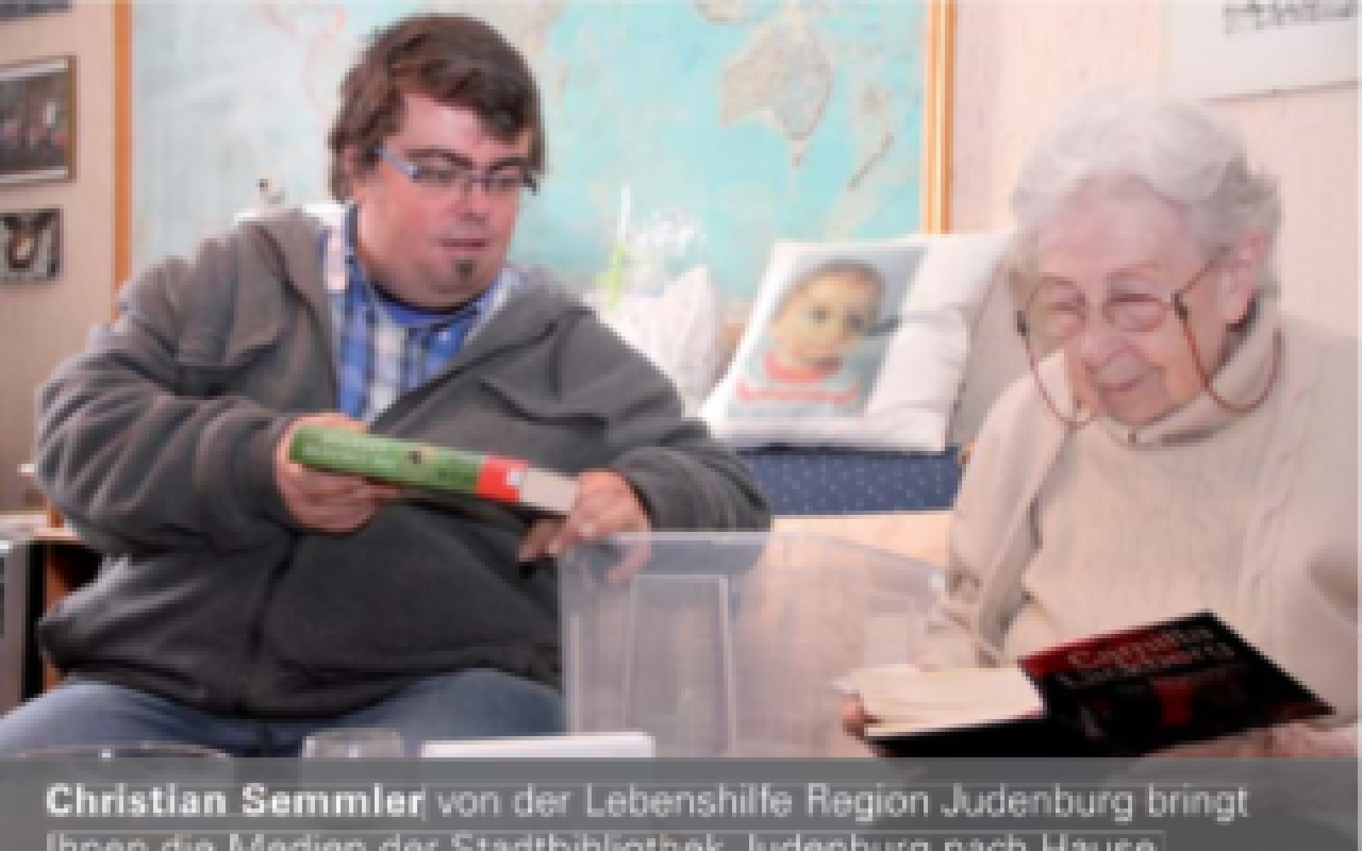 Buch mich: Mann mit Bücherbox und ältere Dame